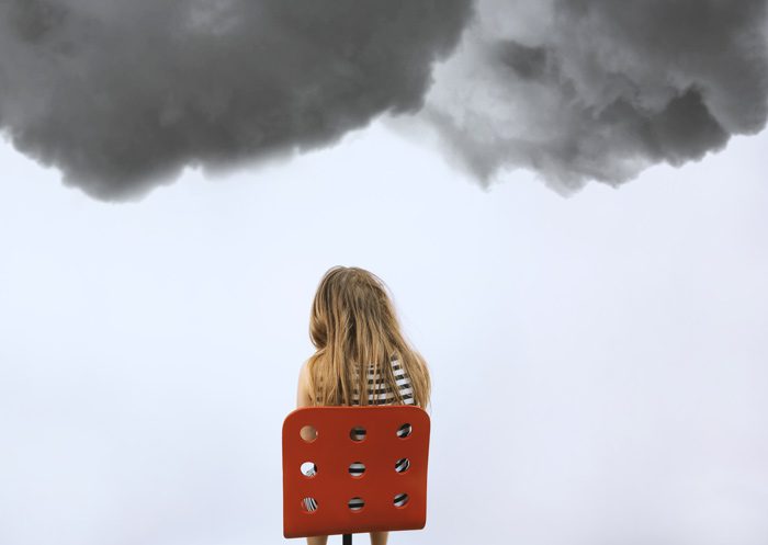 girl sitting in red chair, facing away from the camera, with dark grey storm clouds above her head - depression