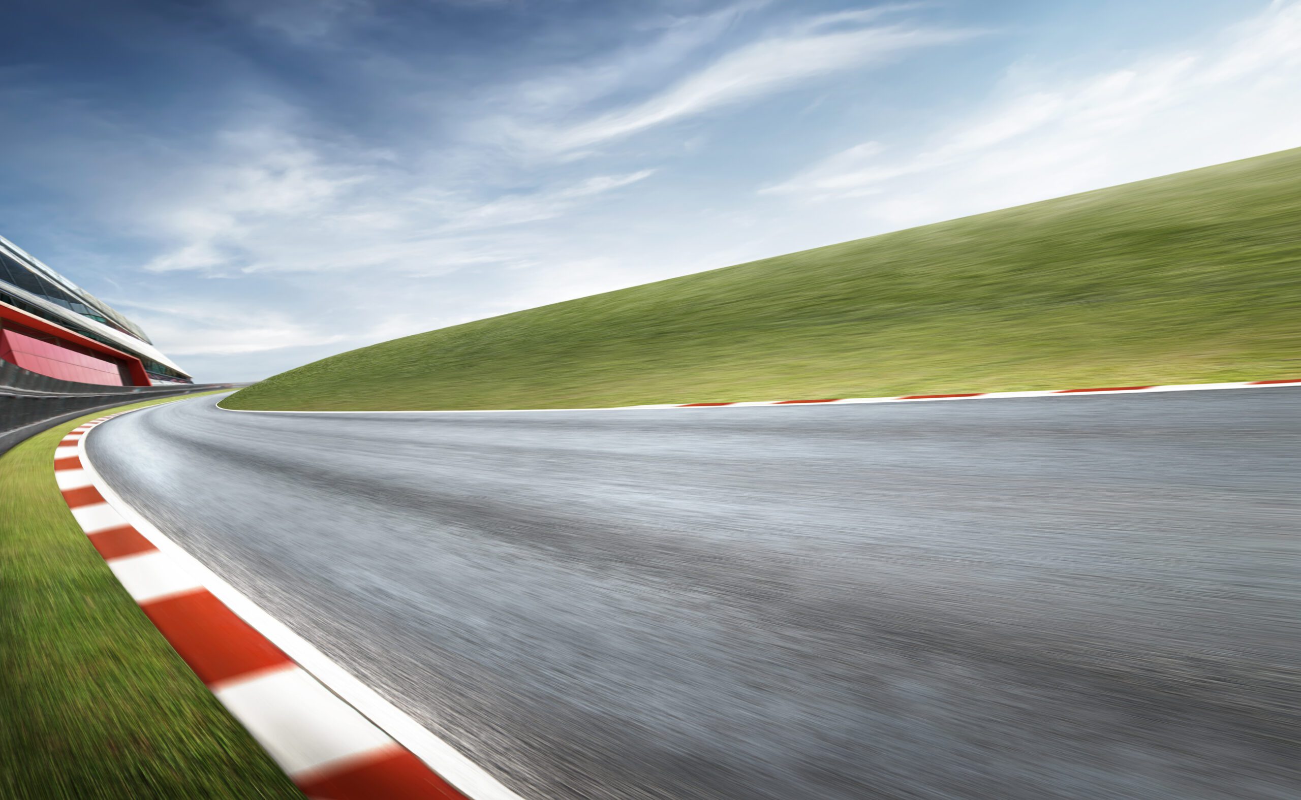 Wide angle view empty asphalt international curvy racetrack , motion blur effect apply . Daytime scene .